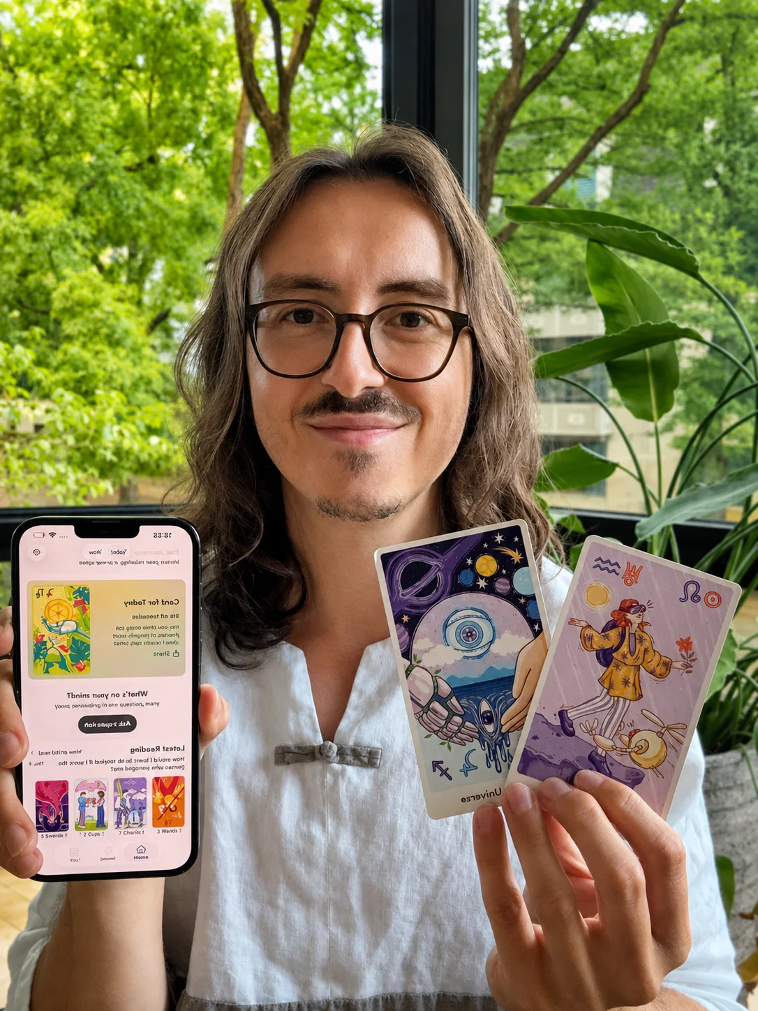 Dan holding Qybala cards and showing the Qybala app
